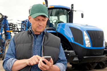 farmer using phone near tractor